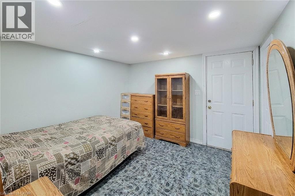 White paneled door with brass hardware, light-toned walls, recessed lighting, and patterned low-pile carpeting - 463 Wellington Street N, Hamilton, ON - Indoor Photo Showing Bedroom