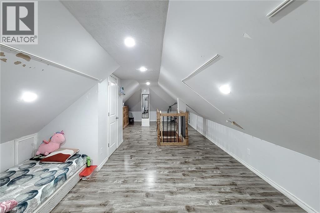 Spacious attic room featuring wood-finish flooring, recessed lighting, and sloped ceilings - 463 Wellington Street N, Hamilton, ON - Indoor Photo Showing Other Room