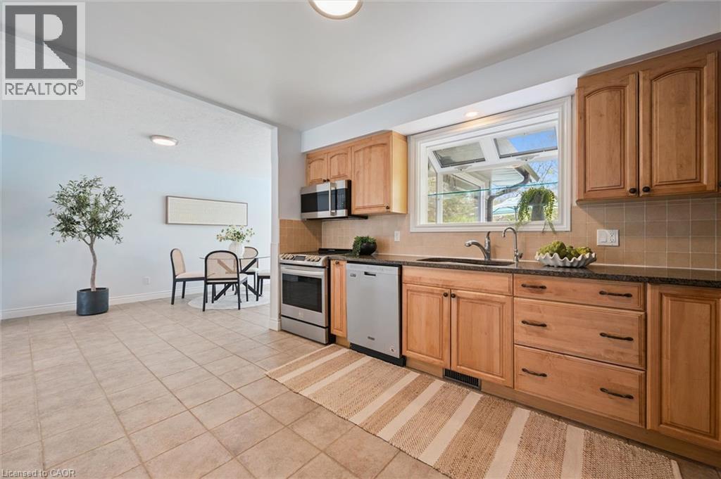 Contemporary kitchen featuring wood cabinetry, stainless steel appliances, and a window above the sink - 176 Woodville Place, Waterloo, ON - Indoor Photo Showing Kitchen