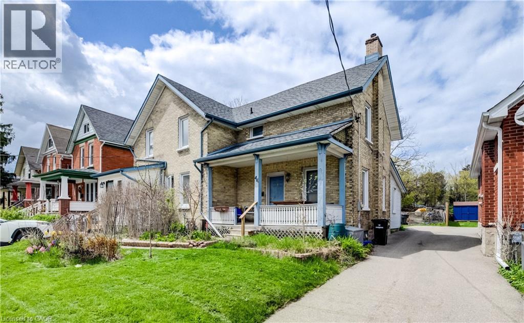 Brick exterior residence featuring a front porch with white railing, a side driveway, and a gabled roofline - 46 Shanley Street, Kitchener, ON - Outdoor With Deck Patio Veranda With Facade