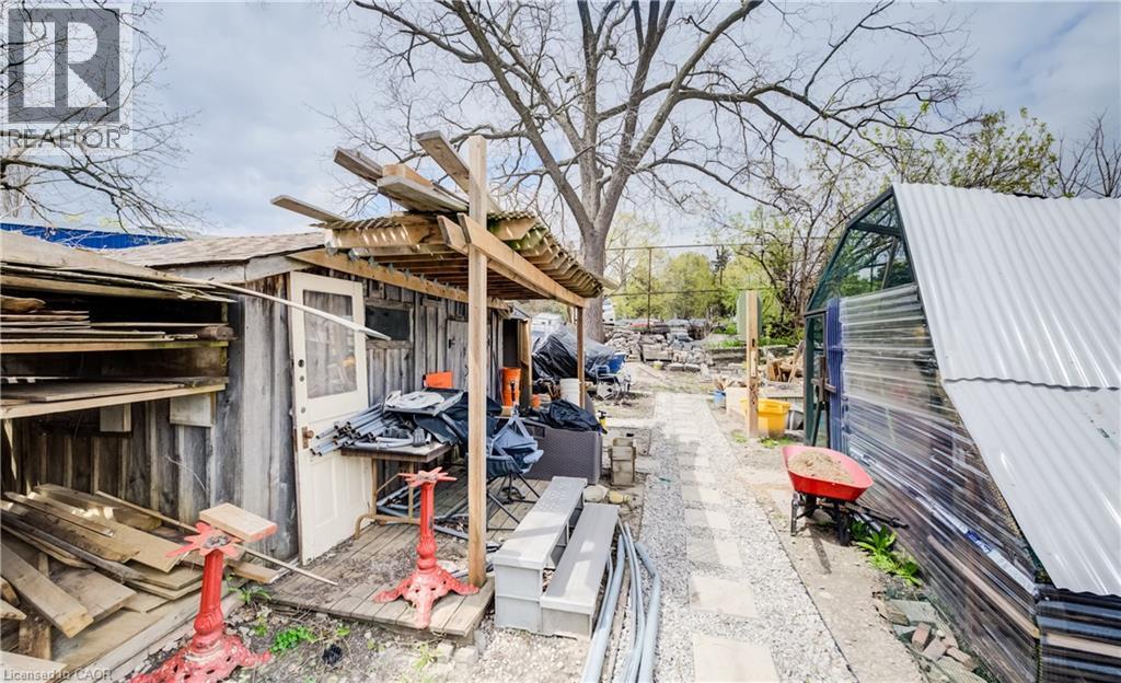 Stone pathway leading to a greenhouse with a corrugated metal roof - 46 Shanley Street, Kitchener, ON - Outdoor