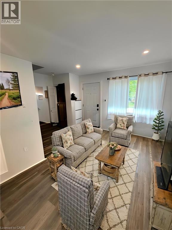 Living area featuring wood-finish flooring, recessed lighting, and a front entry door **Virtually Staged** - 148 Bishop Street S, Cambridge, ON