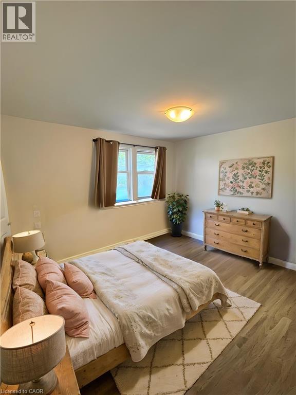 Spacious room featuring wood-finish flooring, a flush-mount ceiling light, and a double window **Virtually Staged** - 148 Bishop Street S, Cambridge, ON