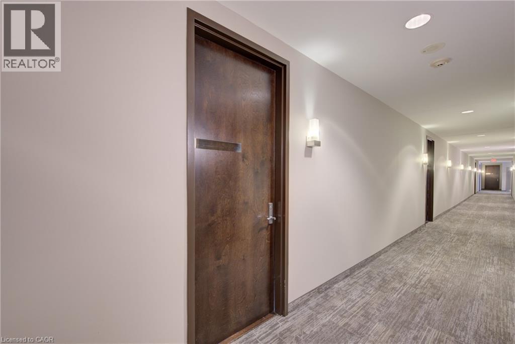 Hallway with wood-finish doors and light-toned walls - 191 King Street S Unit# 607, Waterloo, ON