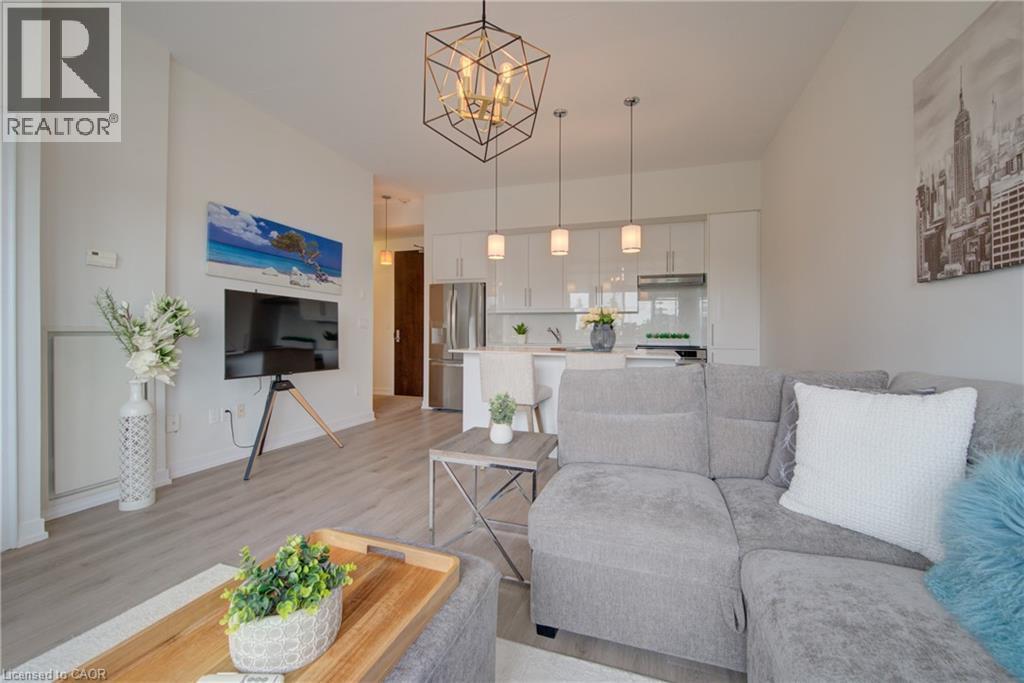 Open-concept living area with light wood-finish flooring - 191 King Street S Unit# 607, Waterloo, ON