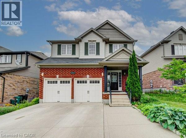 Two-story residence featuring a brick and siding exterior, dual garage doors, a covered porch entrance, and a concrete driveway - 55 Isaiah Drive, Kitchener, ON