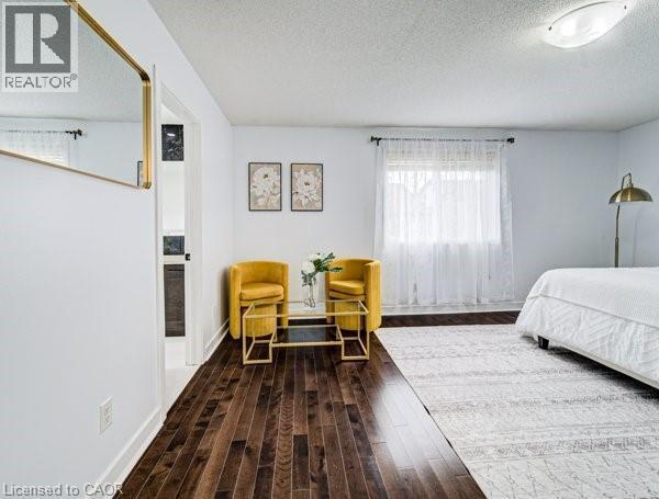 Spacious room featuring rich wood-finish flooring and bright white walls - 55 Isaiah Drive, Kitchener, ON