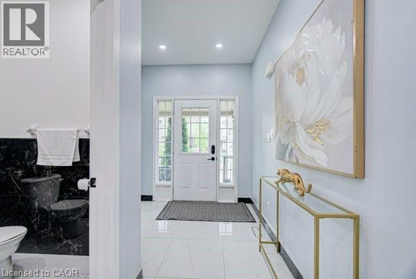 Entryway featuring white tile flooring and a paneled door with sidelights - 55 Isaiah Drive, Kitchener, ON