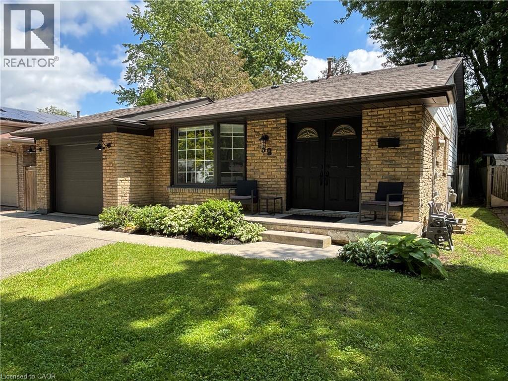 Brick exterior featuring a front entry with double doors, an attached garage, and a concrete walkway - 39 Forestgate Drive, Hamilton, ON