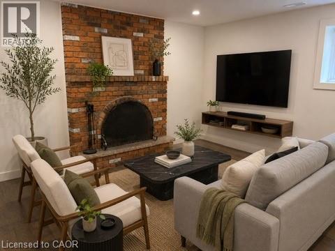 Virtually Staged Lower Unit. Exposed brick fireplace with an arched firebox and stone hearth - 39 Forestgate Drive, Hamilton, ON