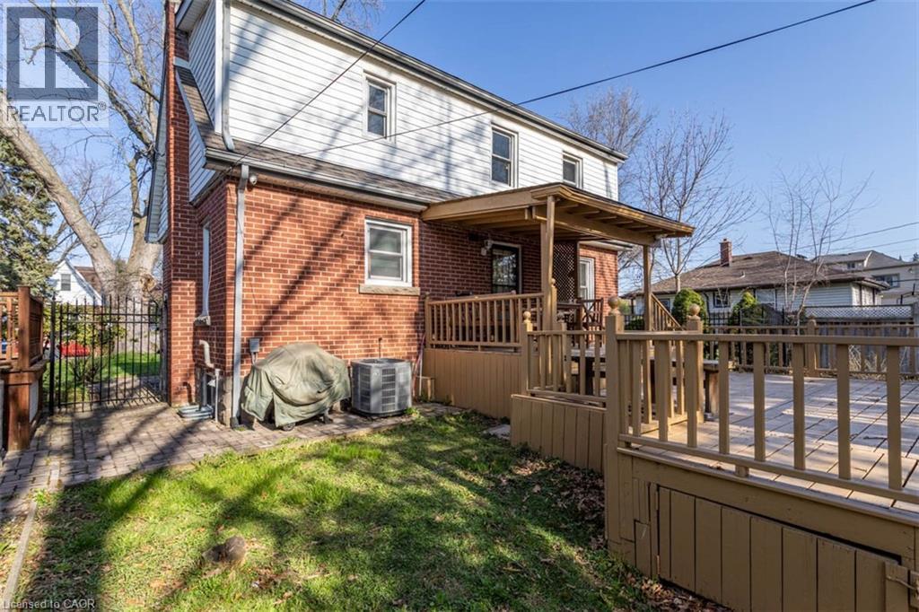 Rear exterior featuring a brick first story and white siding on the second story - 17 Thorndale Street N, Hamilton, ON