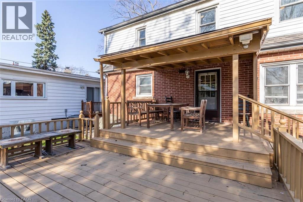 Multi-level wood deck featuring a covered porch area with a brick exterior - 17 Thorndale Street N, Hamilton, ON