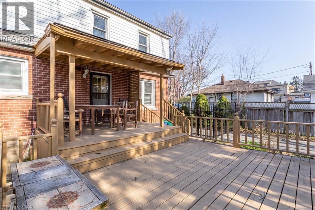 Multi-level wood deck featuring a covered patio area with a wood ceiling - 17 Thorndale Street N, Hamilton, ON