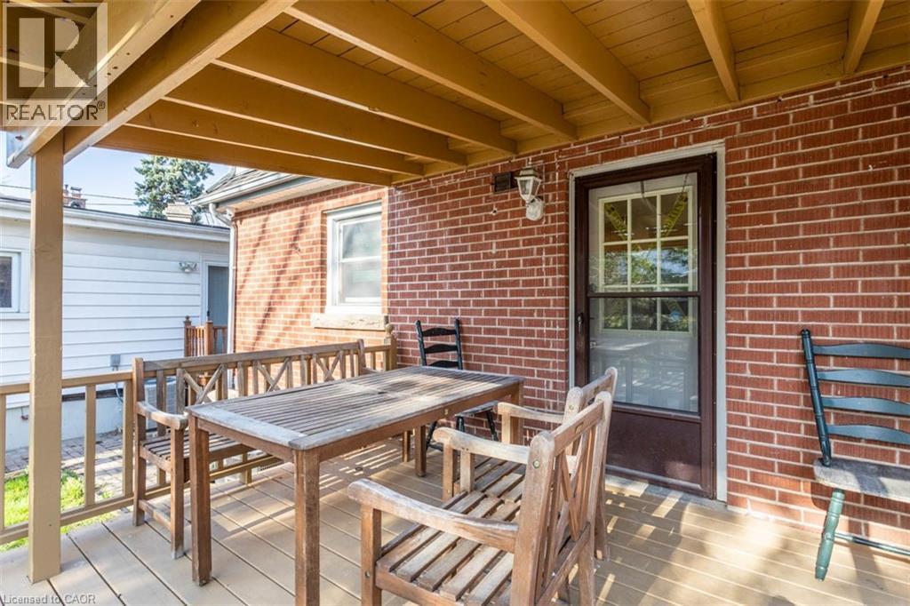 Covered rear porch featuring a wood-finish floor and exposed ceiling joists - 17 Thorndale Street N, Hamilton, ON