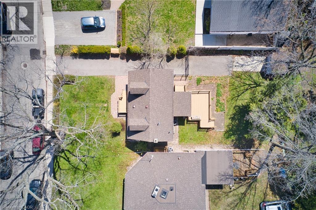Aerial property view featuring a multi-level deck, expansive green lawn, and mature trees - 17 Thorndale Street N, Hamilton, ON