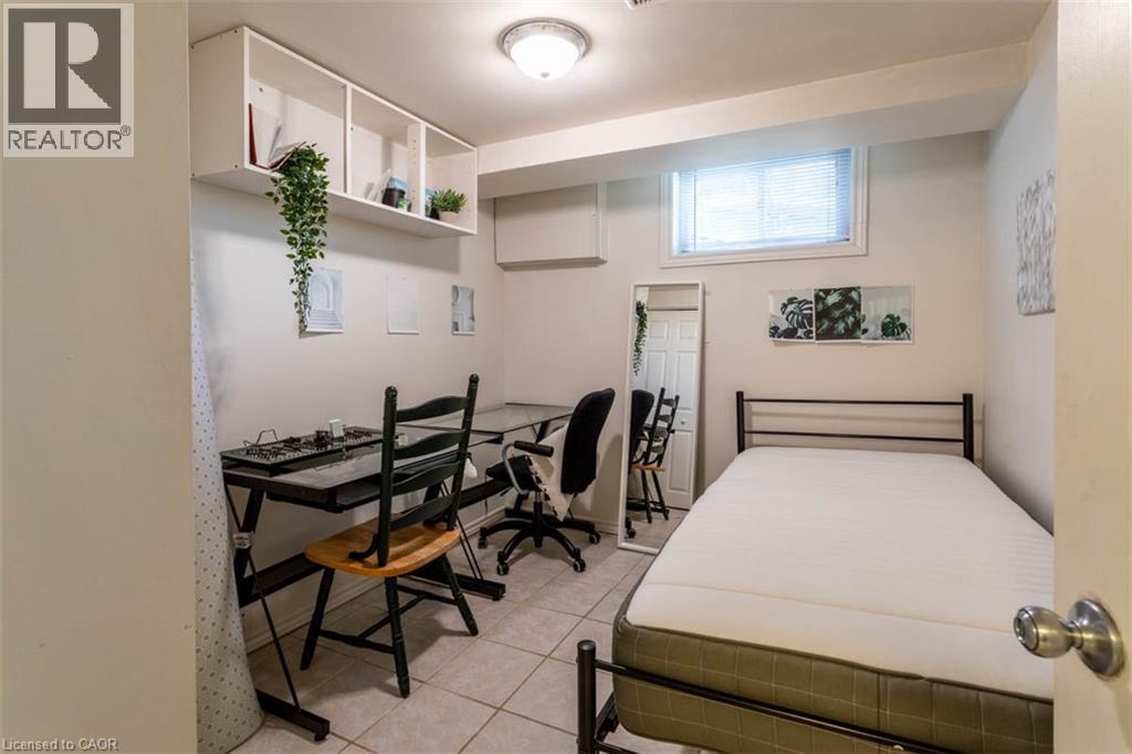 Room featuring tiled flooring, a built-in wall shelf, recessed window with blinds, and white painted walls - 17 Thorndale Street N, Hamilton, ON