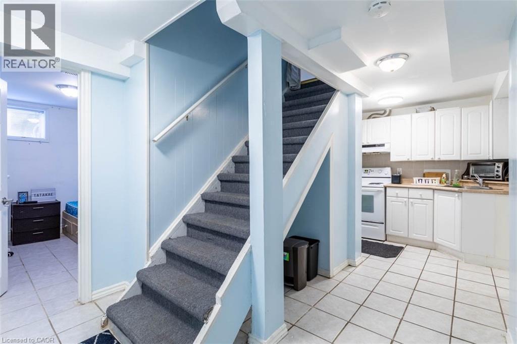 Stairwell with carpeted treads and white handrail leading to an upper level - 17 Thorndale Street N, Hamilton, ON