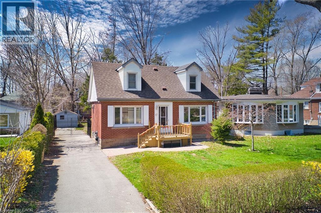 Brick home with dormer windows, featuring a front lawn and paved driveway - 17 Thorndale Street N, Hamilton, ON