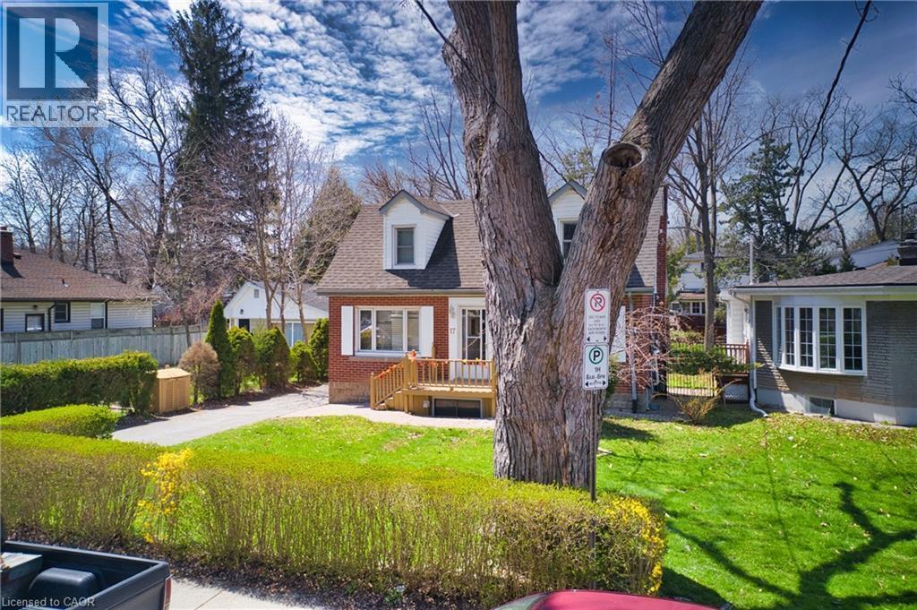 Brick exterior with dormer windows, a front deck, and a driveway - 17 Thorndale Street N, Hamilton, ON