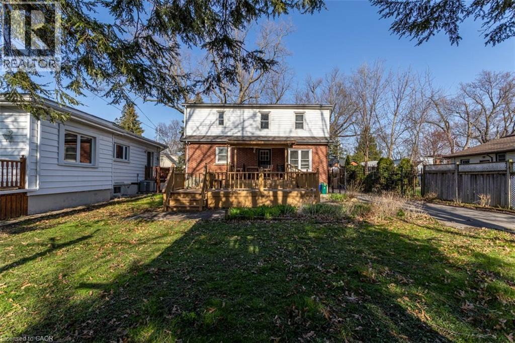 Expansive backyard featuring a multi-level wood deck, brick-sided structure, and mature perimeter trees - 17 Thorndale Street N, Hamilton, ON