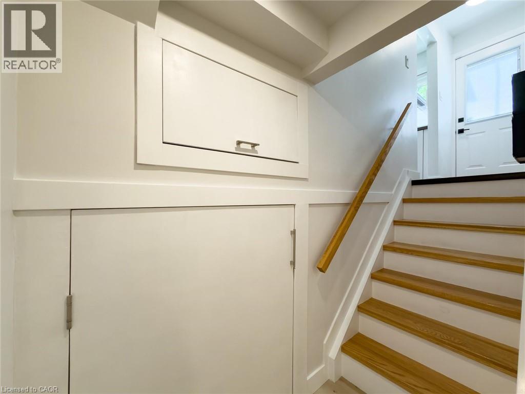 Staircase featuring wood treads, white risers, and a natural wood handrail - 1324 Bodley Road, Mississauga, ON