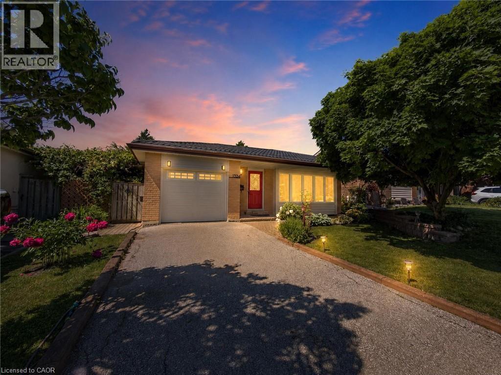 Brick and siding exterior featuring a prominent red entry door - 1324 Bodley Road, Mississauga, ON