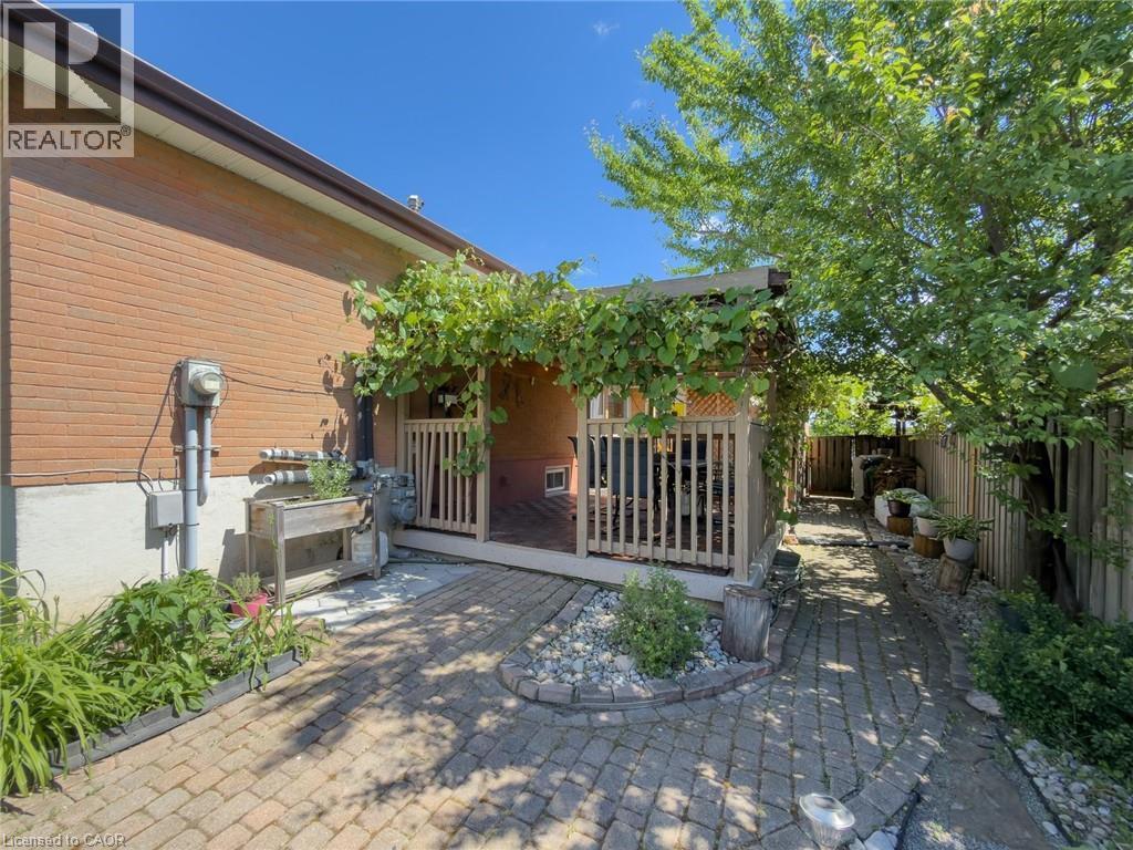 Brick exterior with a covered wood deck featuring a lattice privacy screen - 1324 Bodley Road, Mississauga, ON
