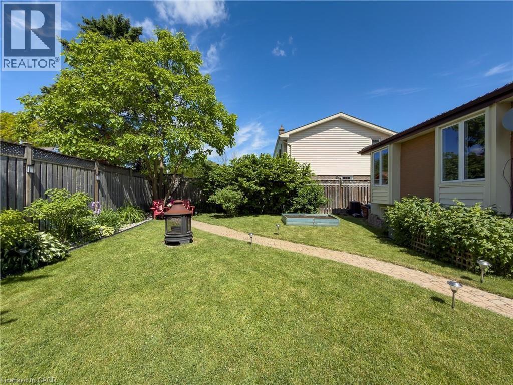 Expansive backyard featuring a manicured lawn, established perimeter fencing, and mature trees - 1324 Bodley Road, Mississauga, ON