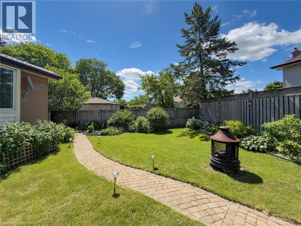 Expansive lawn featuring a paver stone pathway and mature perimeter plantings - 1324 Bodley Road, Mississauga, ON