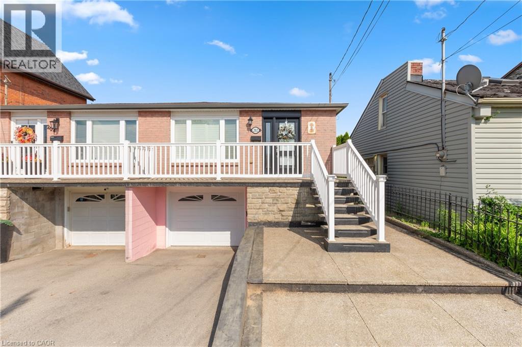 Brick and stone facade residence featuring a white balcony railing. - 202 Ray Street N, Hamilton, ON - Outdoor
