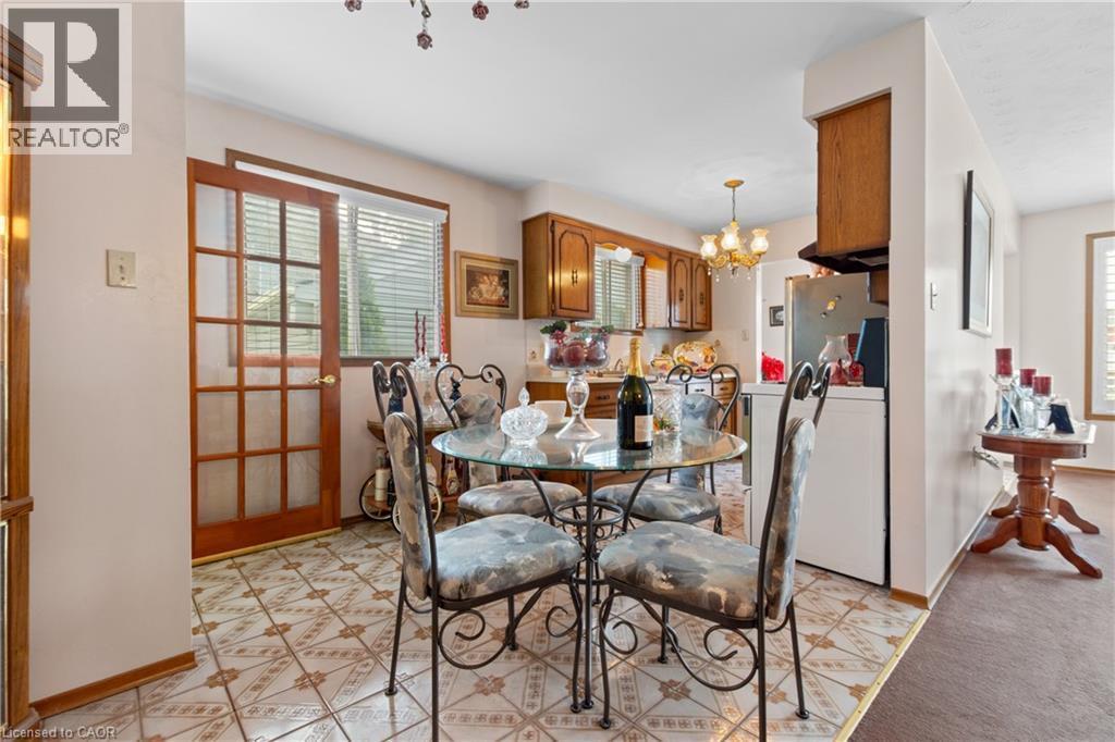 Kitchen area featuring wood-finish cabinetry, patterned tile flooring, and a glass-paneled door. - 202 Ray Street N, Hamilton, ON - Indoor Photo Showing Dining Room