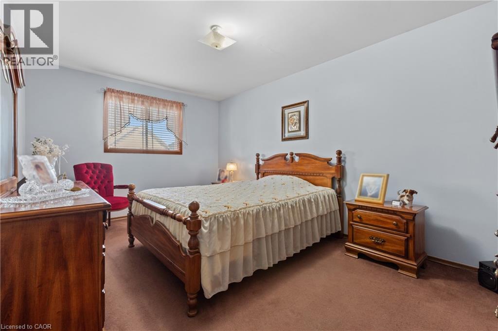 Bedroom featuring light blue painted walls, brown carpet flooring, and a flush-mount ceiling light. - 202 Ray Street N, Hamilton, ON - Indoor Photo Showing Bedroom
