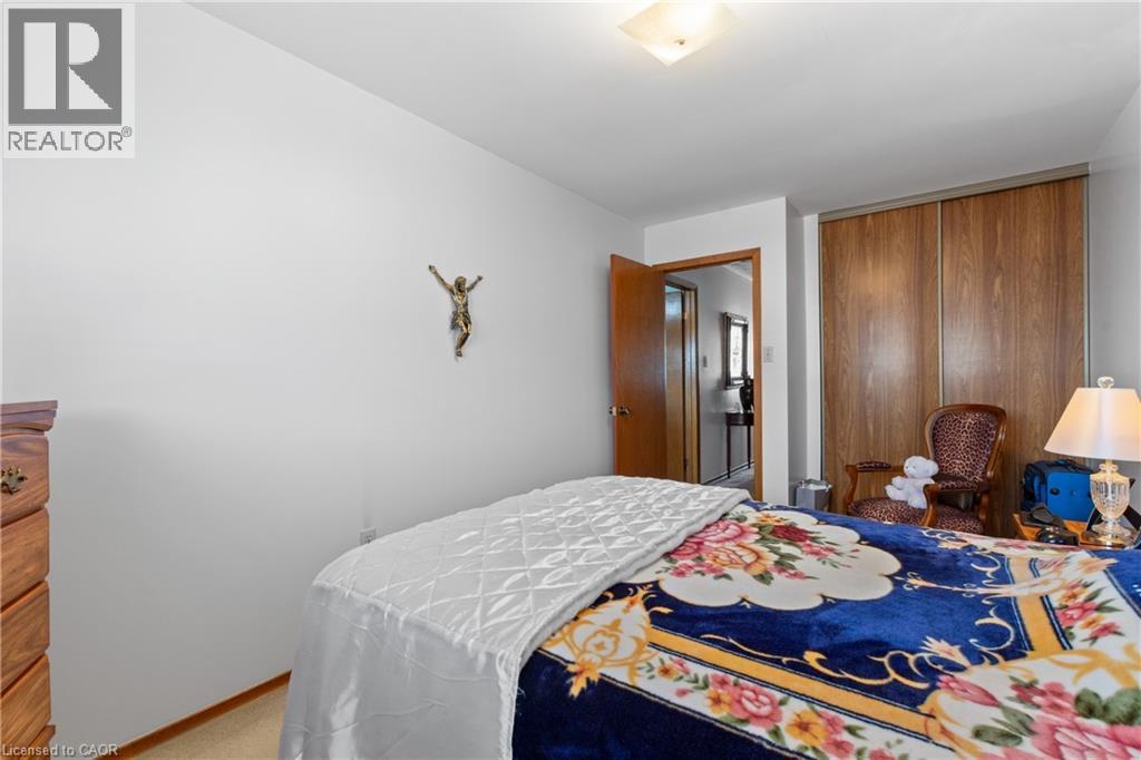 Spacious bedroom featuring light-colored walls, wood-finish flooring, and a ceiling-mounted light fixture. - 202 Ray Street N, Hamilton, ON - Indoor Photo Showing Bedroom