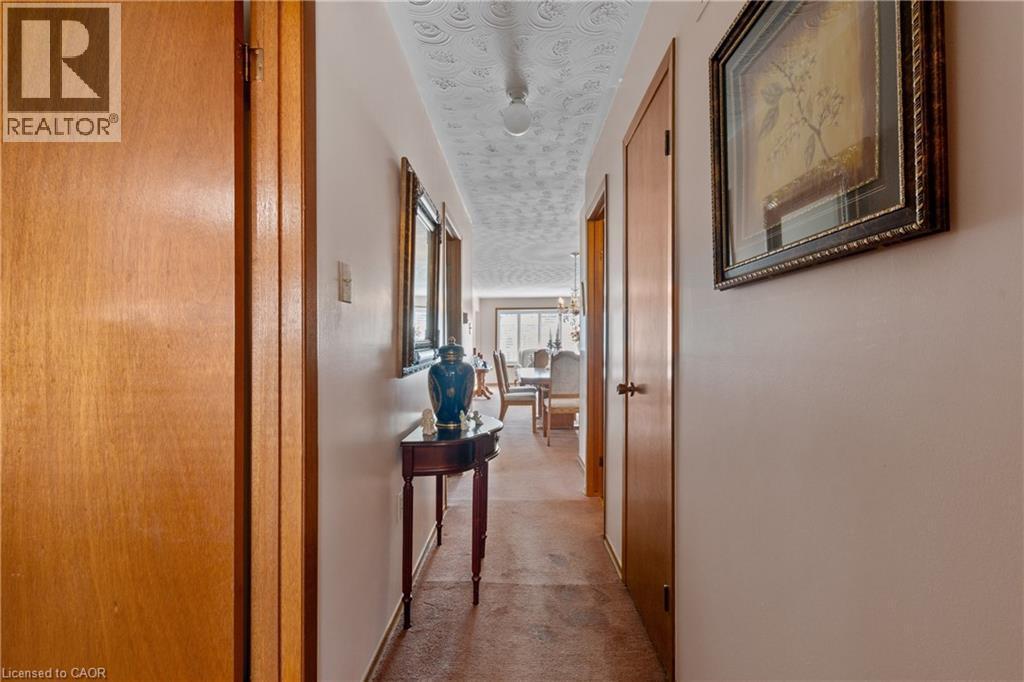 Hallway featuring textured ceiling, light wood-finish doors, and neutral wall paint. - 202 Ray Street N, Hamilton, ON - Indoor Photo Showing Other Room