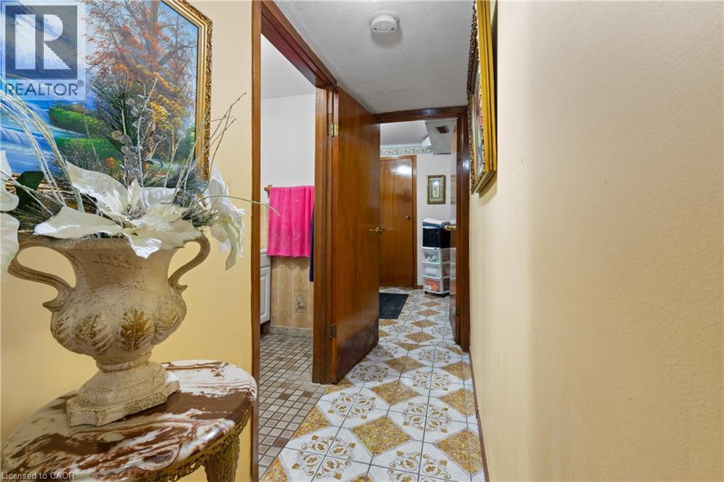 Tiled flooring in a geometric pattern. extends through the hallway, complemented by warm-toned walls - 202 Ray Street N, Hamilton, ON - Indoor Photo Showing Other Room