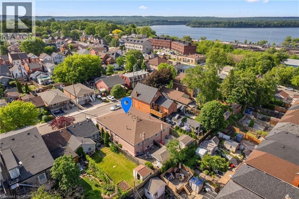 Two-story residential property with a light-colored exterior and a brown shingle roof. - 202 Ray Street N, Hamilton, ON - Outdoor With Body Of Water With View