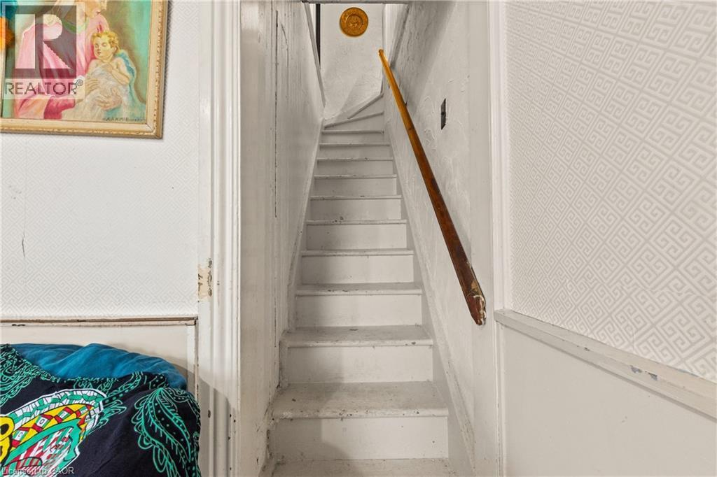 Staircase with painted treads and risers, featuring a wood handrail. - 193 Locke Street N, Hamilton, ON - Indoor Photo Showing Other Room