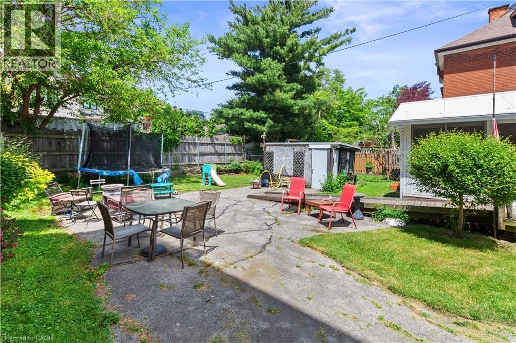 Expansive backyard featuring a combination of grassy areas and a concrete patio. - 193 Locke Street N, Hamilton, ON - Outdoor With Deck Patio Veranda With Backyard