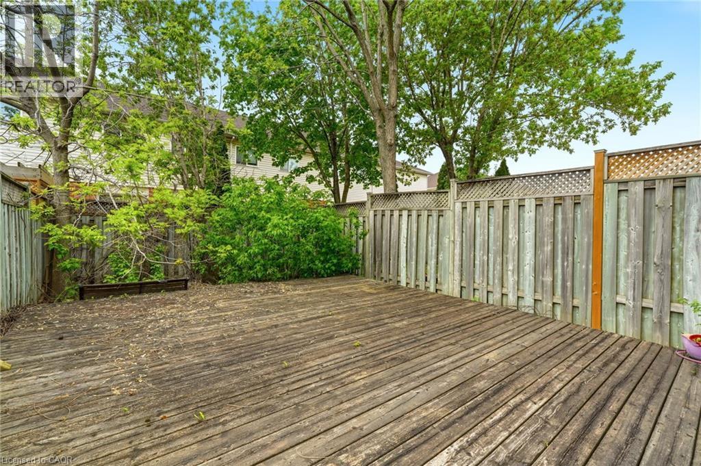 Expansive wood deck with plank construction, surrounded by a wood privacy fence featuring lattice accents - 4413 Peter Drive, Burlington, ON