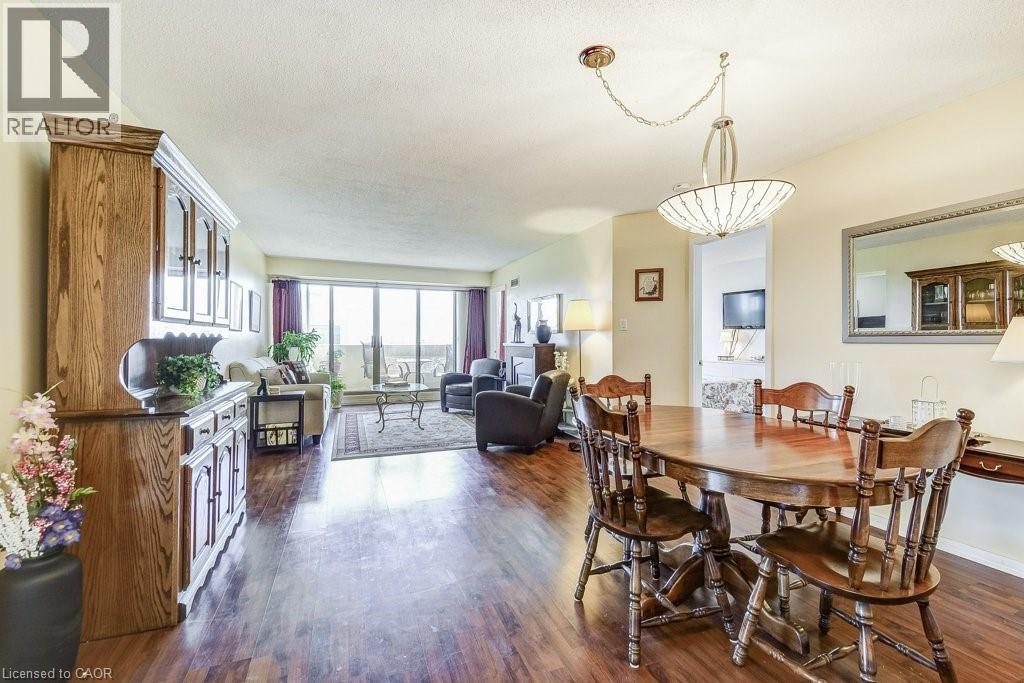 Spacious interior featuring wood-finish flooring, a contemporary dining chandelier, and recessed lighting - 1201 North Shore Boulevard E Unit# 706, Burlington, ON - Indoor Photo Showing Dining Room