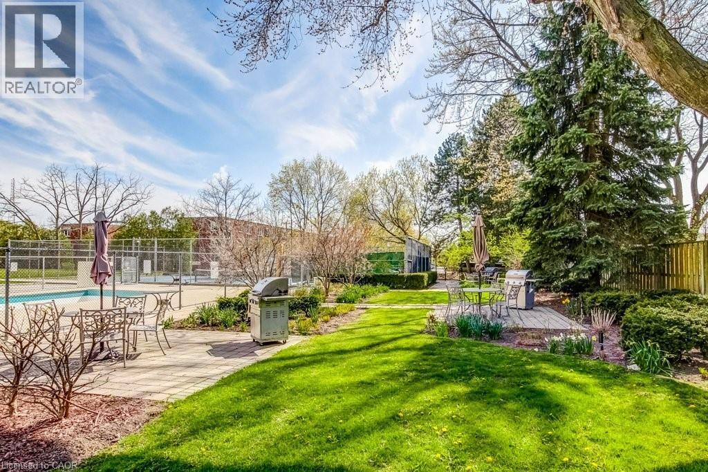 Spacious outdoor area featuring a swimming pool, paved patio, and manicured lawn - 1201 North Shore Boulevard E Unit# 706, Burlington, ON - Outdoor