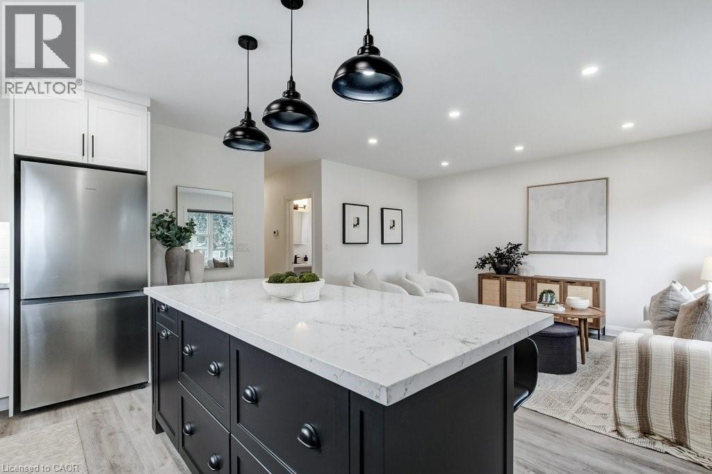 Kitchen island featuring a white countertop and dark cabinetry with matte black hardware - 202 Erindale Avenue, Hamilton, ON