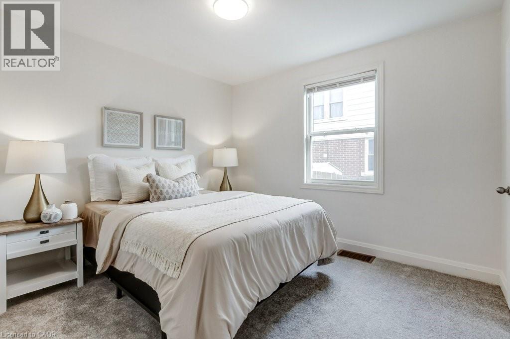 Carpeted bedroom featuring white walls, a single window with blinds, and an overhead flush-mount light fixture - 202 Erindale Avenue, Hamilton, ON