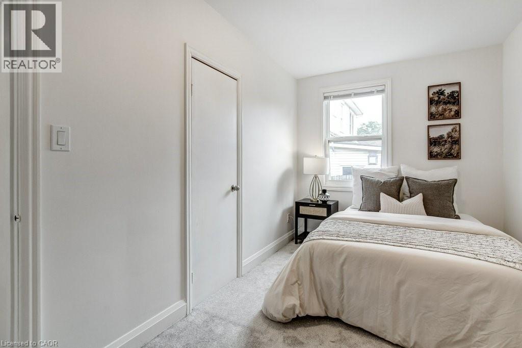 Carpeted room with white walls and trim, featuring a double-hung window with blinds - 202 Erindale Avenue, Hamilton, ON