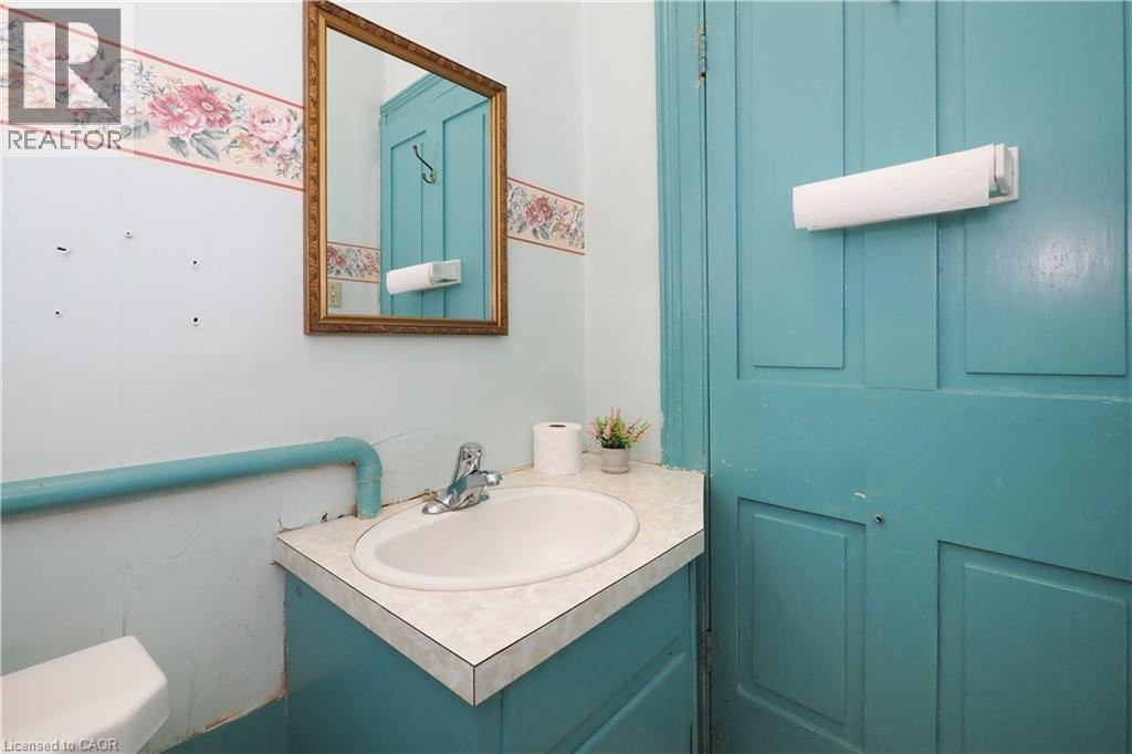 Bathroom vanity featuring a laminate countertop, integrated sink, and chrome faucet - 731 King Street E, Cambridge, ON