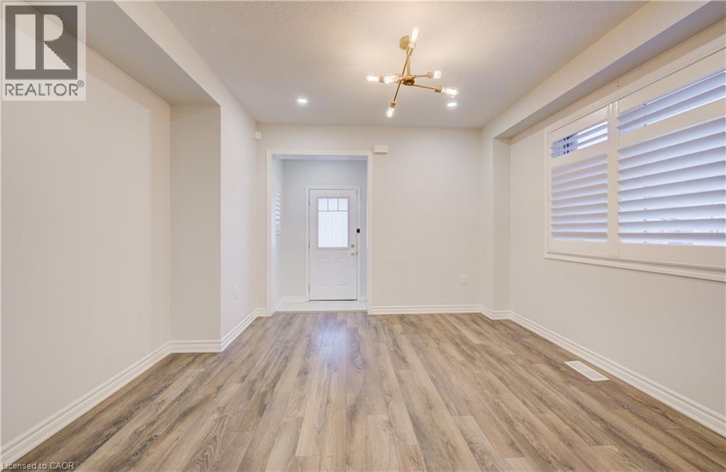 Entrance foyer with hanging lights and light wood finished floors - 302 Jean Landing, Milton, ON