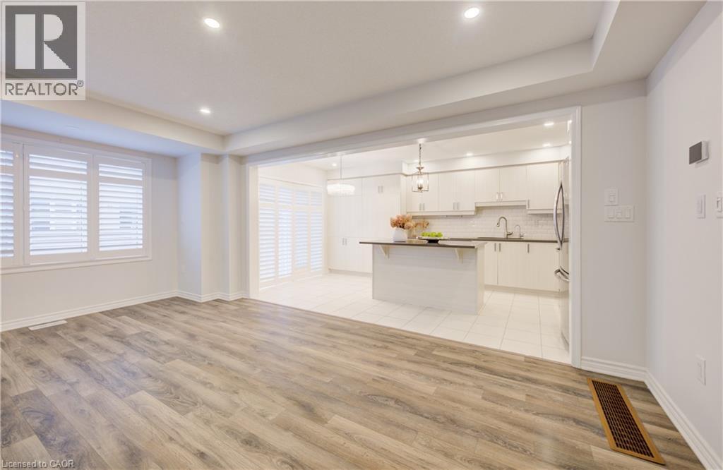 Unfurnished living room with light wood-type flooring, recessed lighting, and a raised ceiling - 302 Jean Landing, Milton, ON