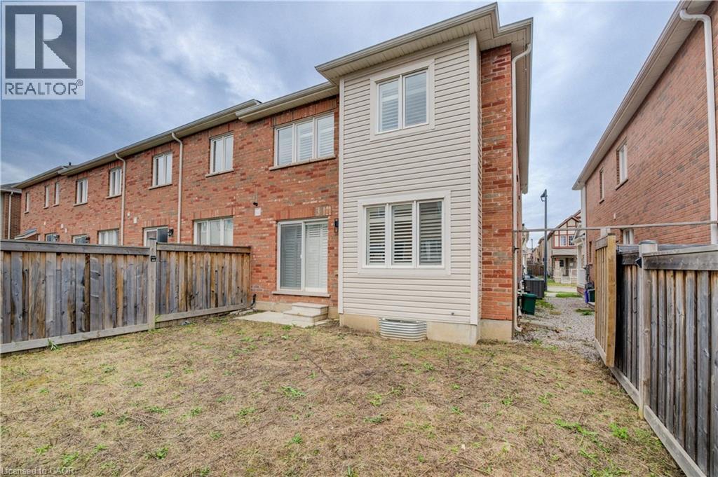 Back of house featuring a fenced backyard, entry steps, and brick siding - 302 Jean Landing, Milton, ON