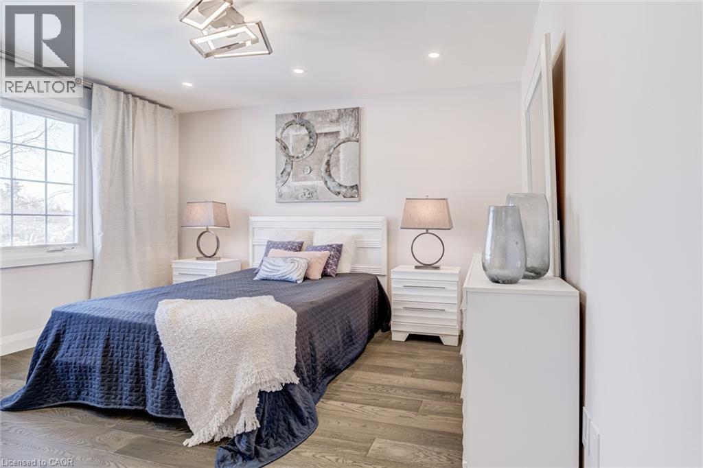Interior room featuring wood-finish flooring, white walls, and a large window with white trim - 1320 Monmouth Drive, Burlington, ON