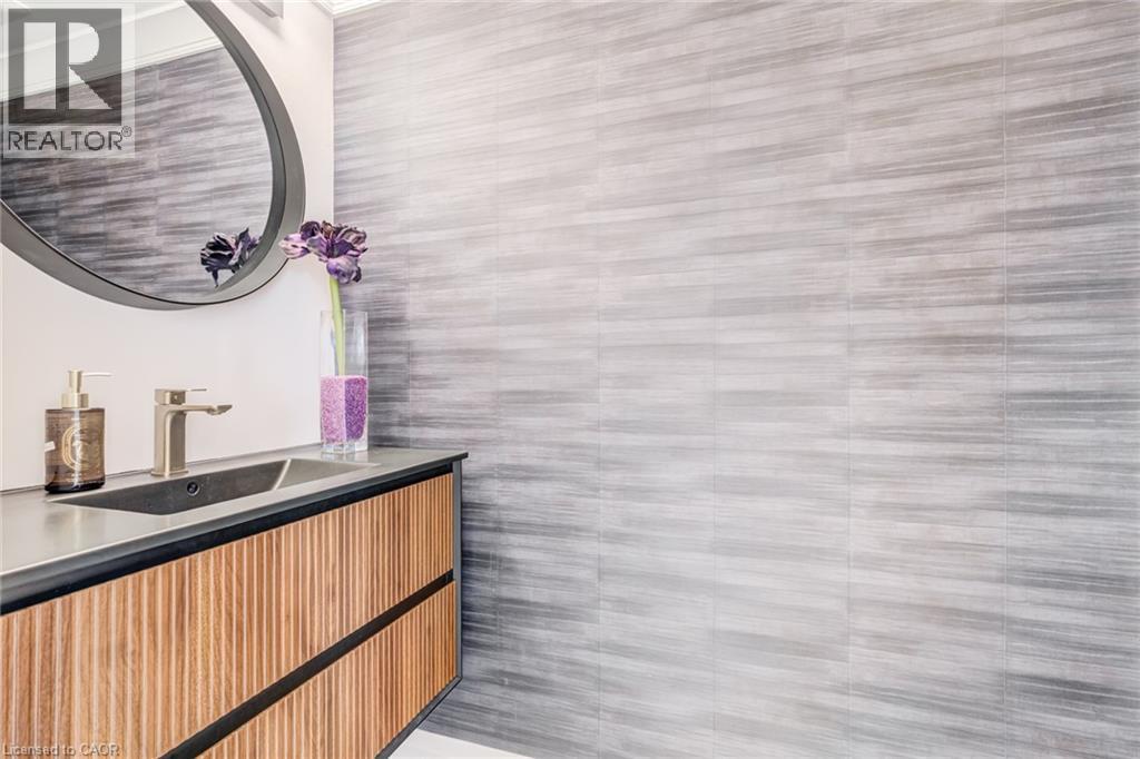 Wall-mounted vanity featuring wood-finish cabinetry and an integrated basin with a brushed nickel faucet - 1320 Monmouth Drive, Burlington, ON